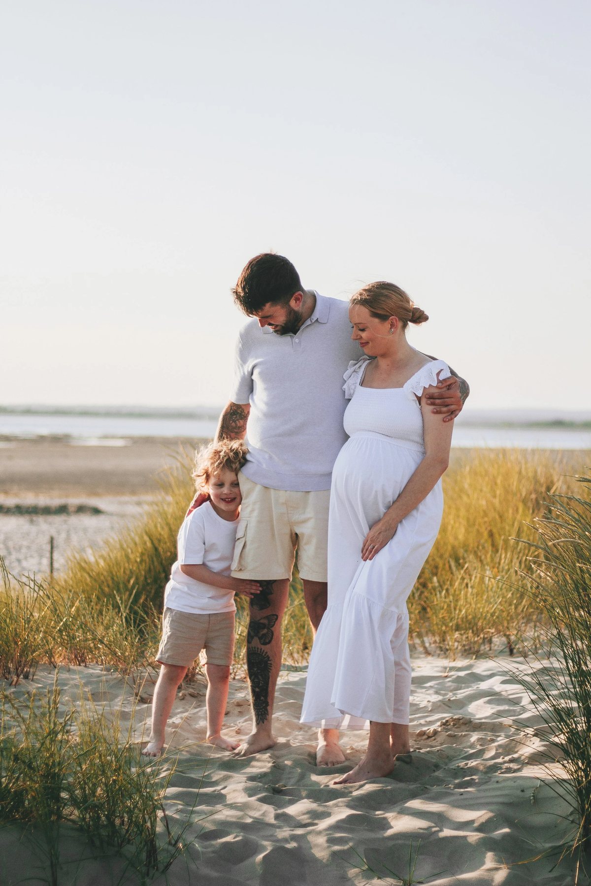 A family silhouetted against low evening sun on the sand at West Wittering